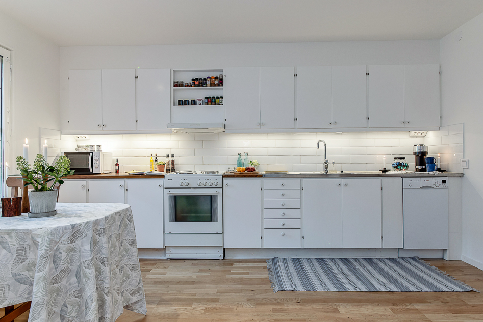 Vitt kök med plats för stora sällskap