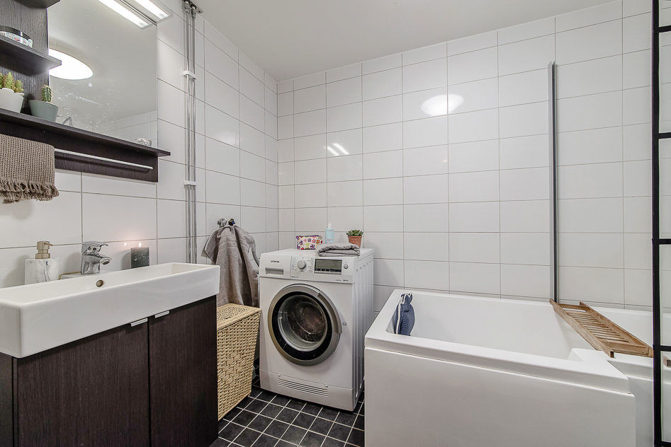 Badrum med tvättmaskin och badkar